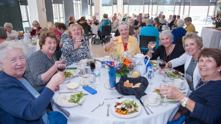A group of Ϲ alumni make a toast together at the reunion