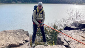 Photo of Quinn Bruning getting ready to rappel down a cliff